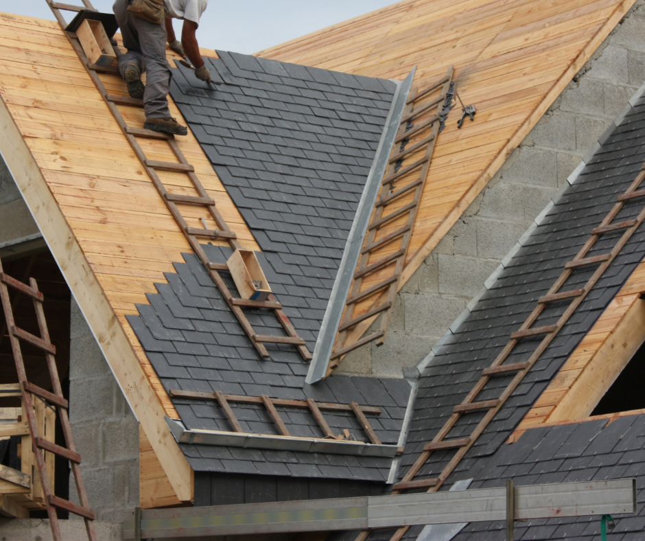 Two men are working on the roof of a building