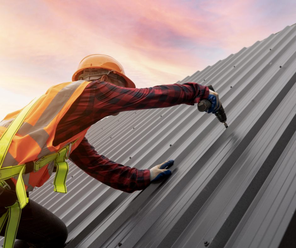 A man is installing a metal roof with a drill.