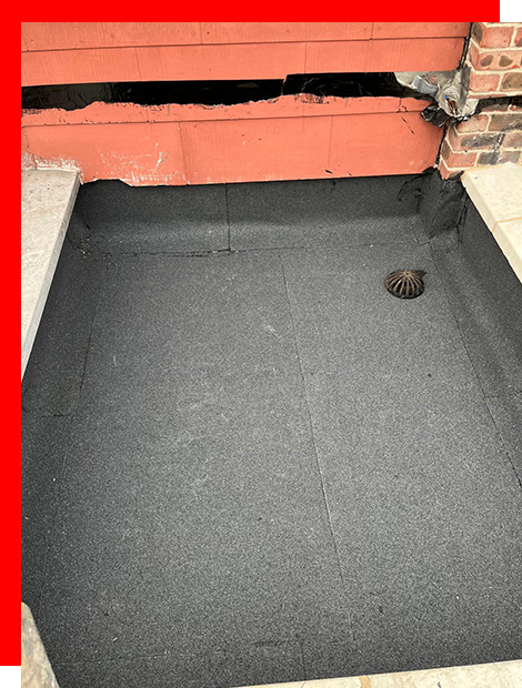 a drain hole in the ground next to a brick wall .