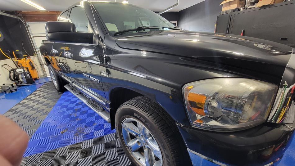 A black dodge ram truck is parked in a garage.