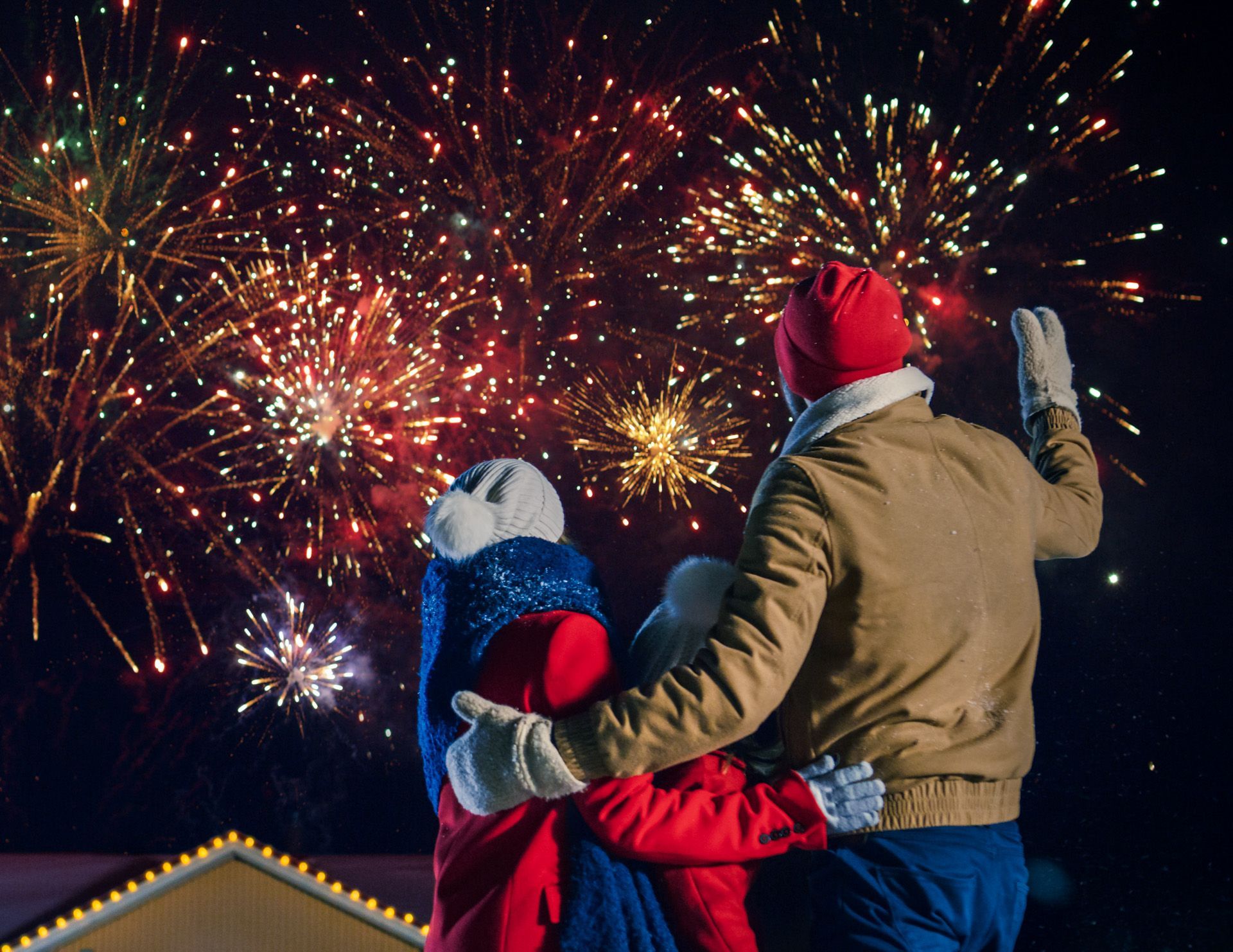 A man and woman are watching a fireworks display
