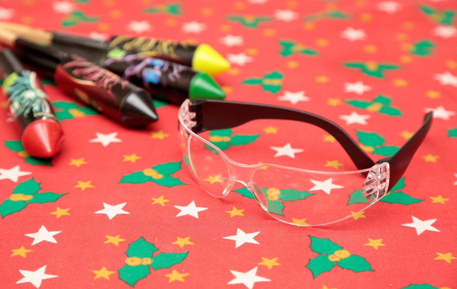 A pair of safety glasses sitting on top of a red table cloth.