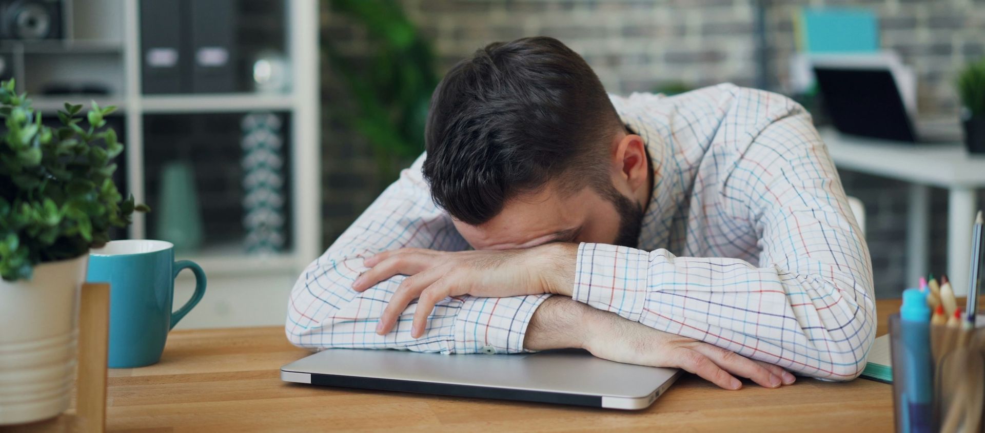 Man with head down on laptop
