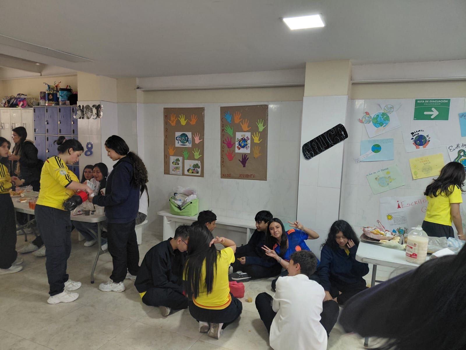 Varias personas se reunieron en un aula, conversando y sentadas en el suelo durante una actividad grupal.
