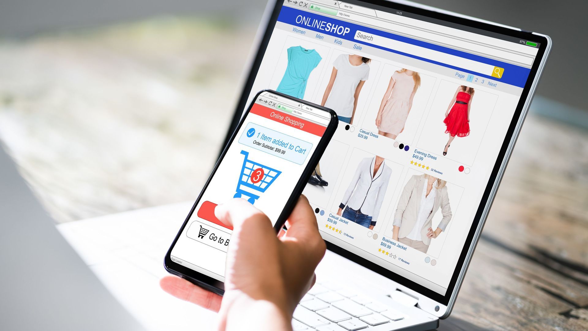 Person shopping online for clothes on a laptop and phone. Shopping cart icon displayed on phone.