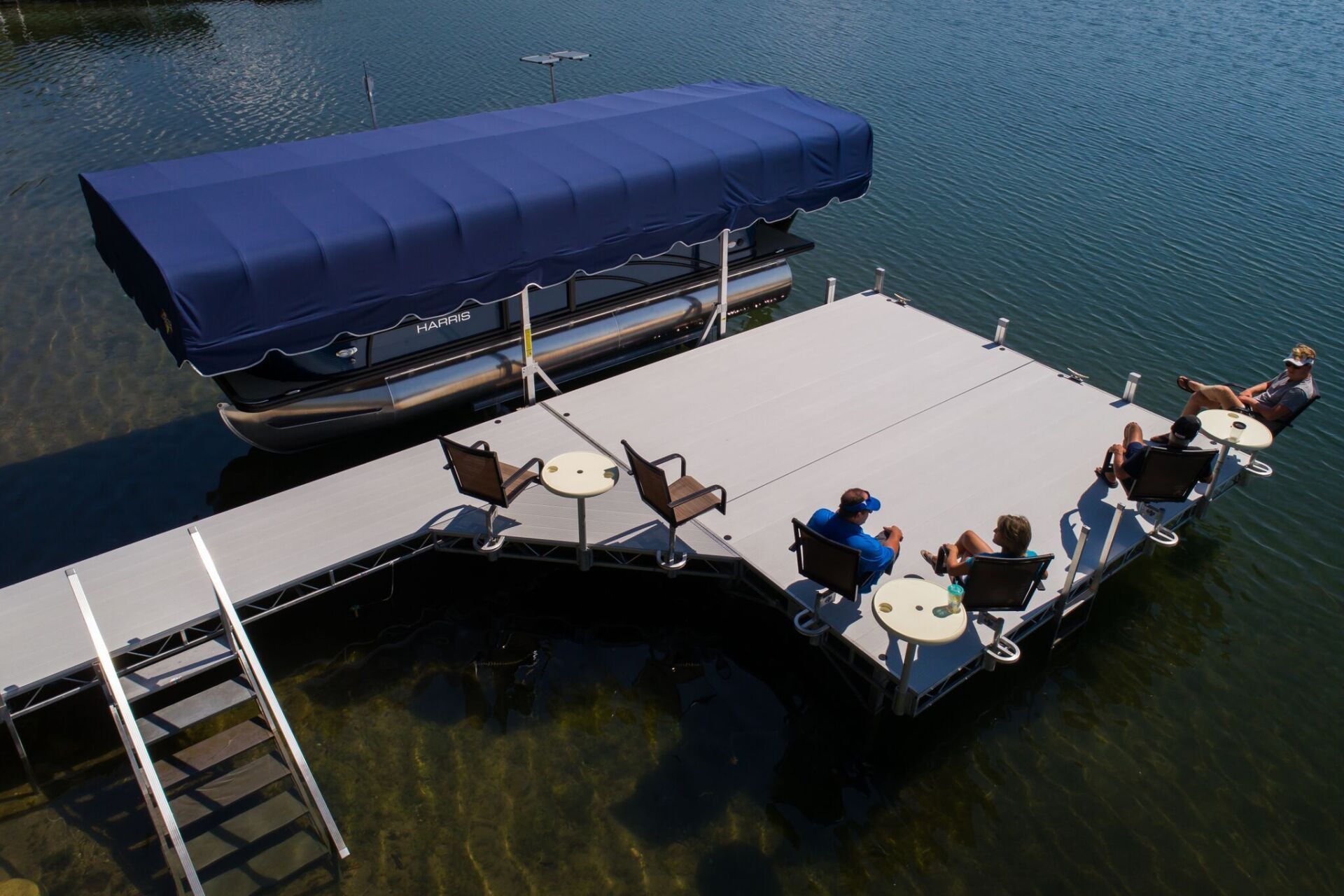 A group of people are sitting on a dock next to a boat.