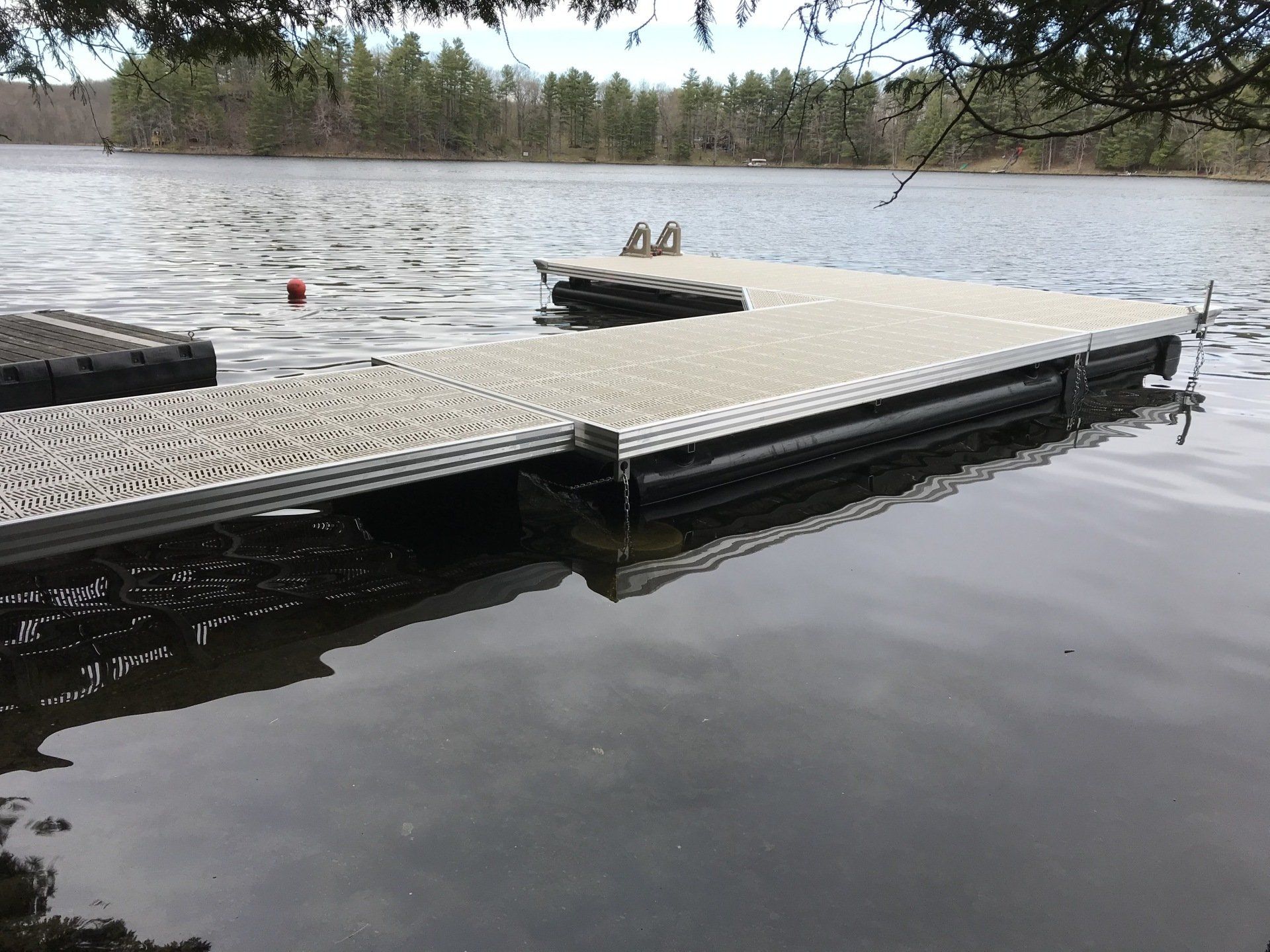 A dock in the middle of a lake with trees in the background