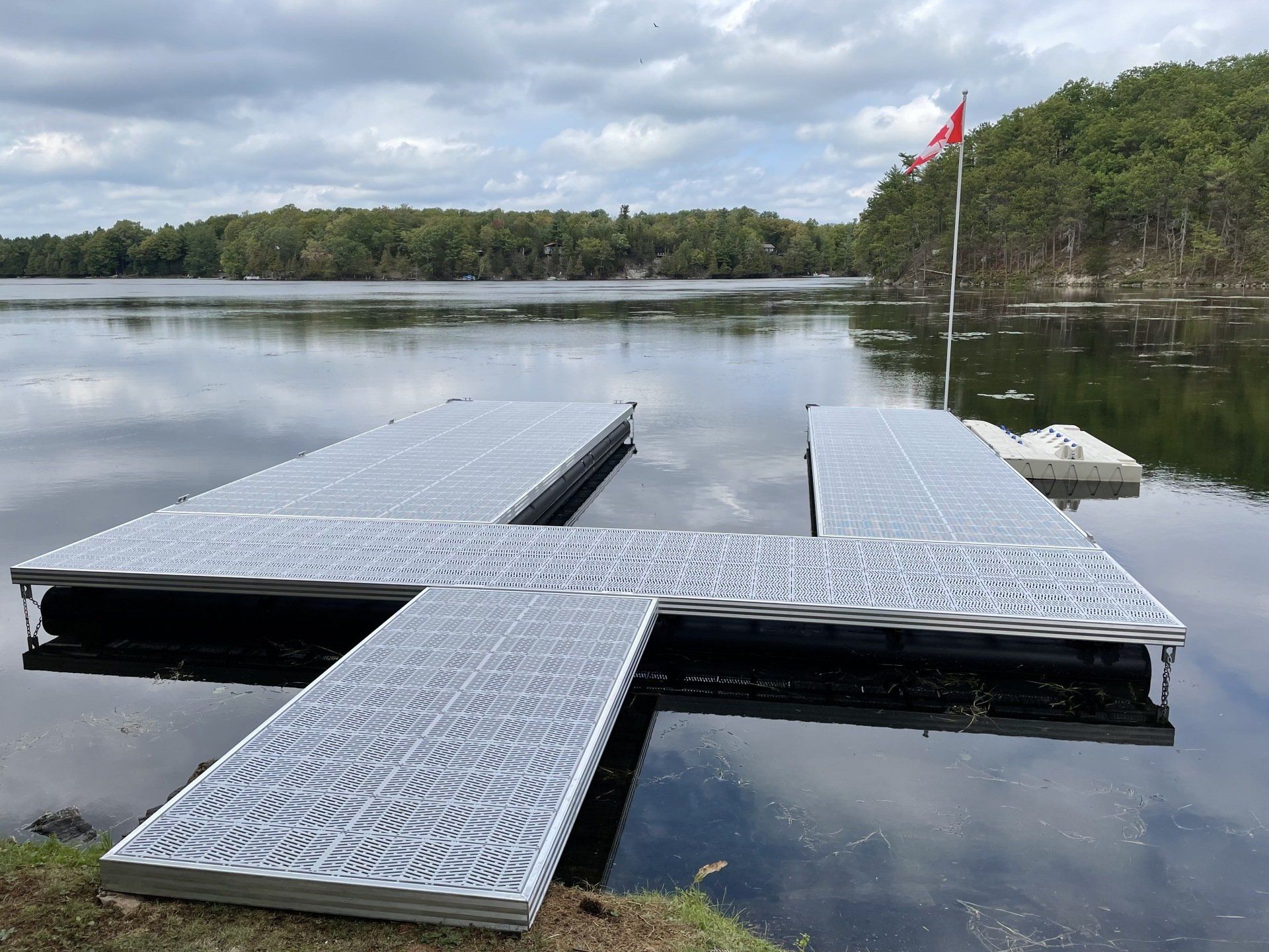A dock on a lake with a red flag in the background
