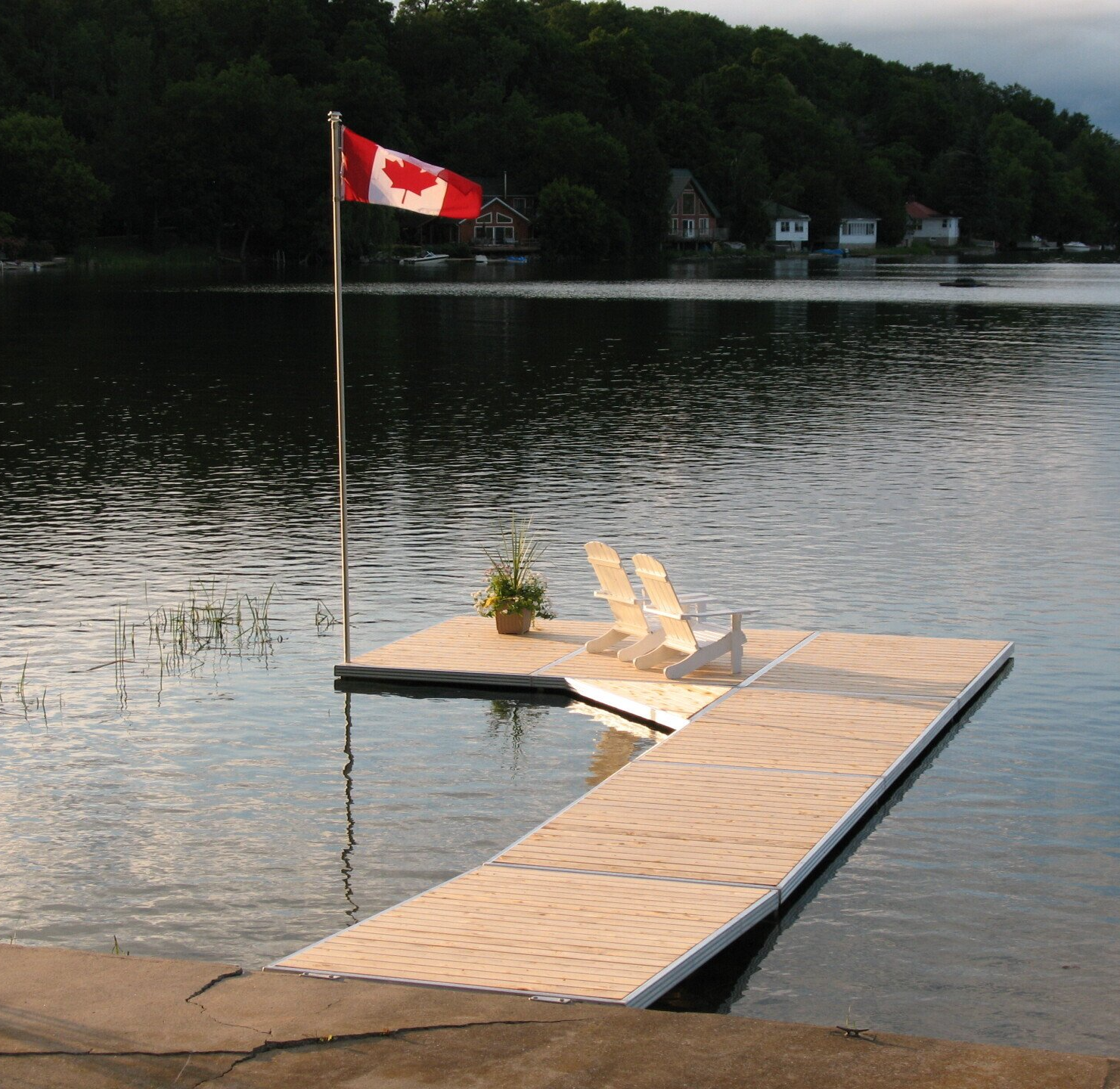A canadian flag is flying over a dock in the water