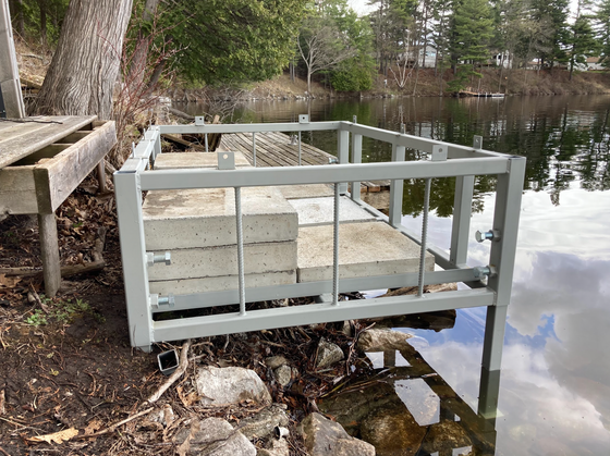 A dock is sitting next to a body of water.