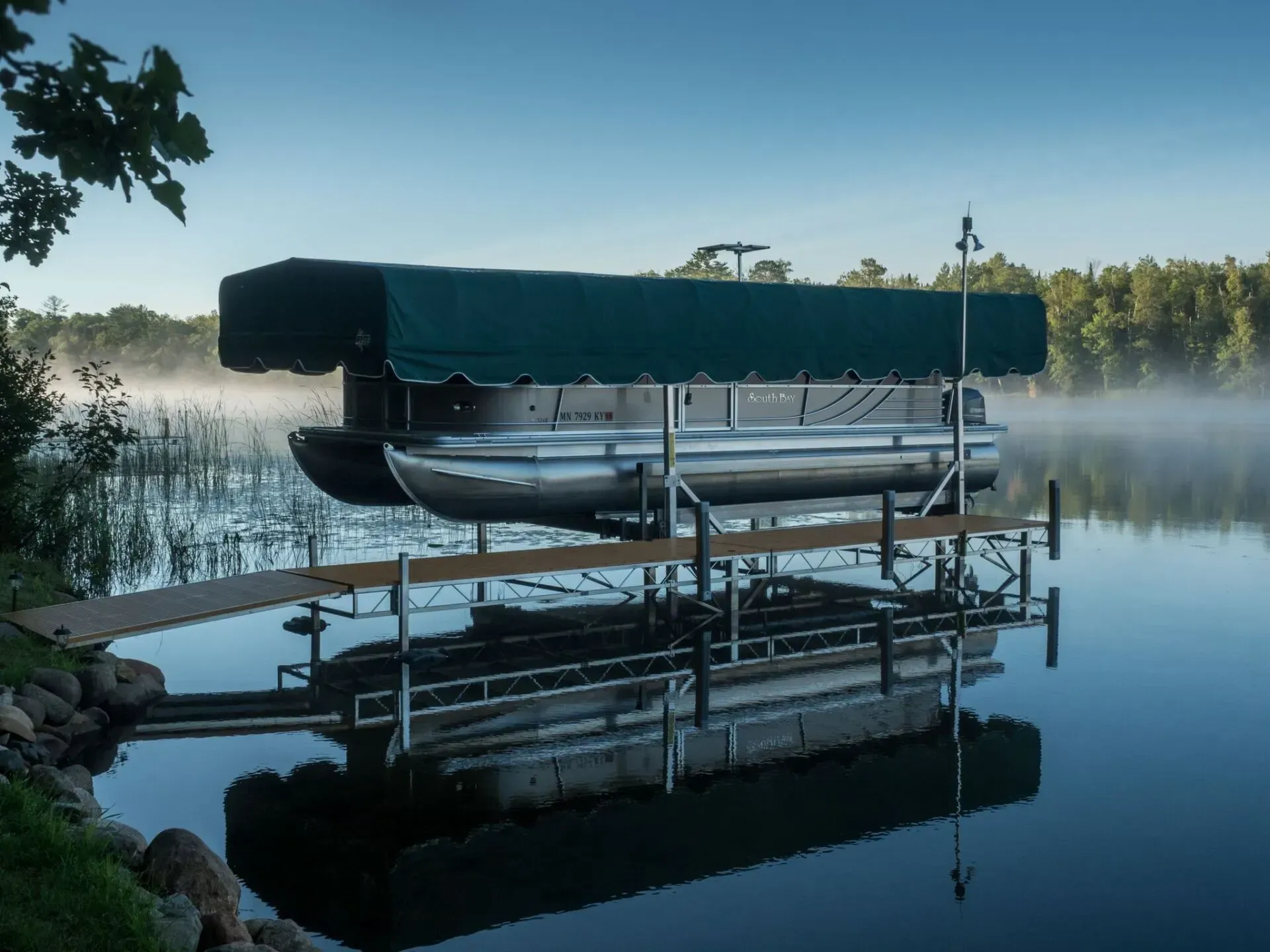 Boat on boat lift next to dock