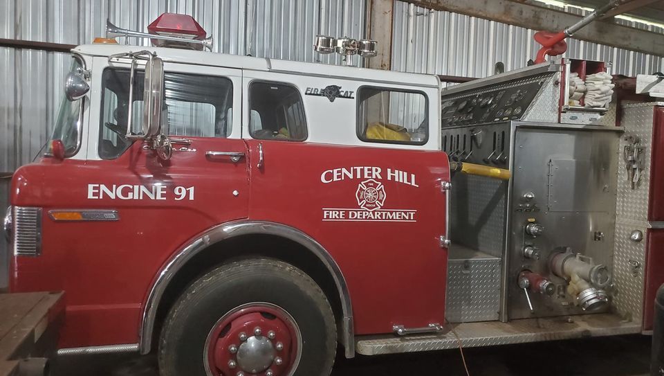 A Center Hill fire truck is parked in a garage