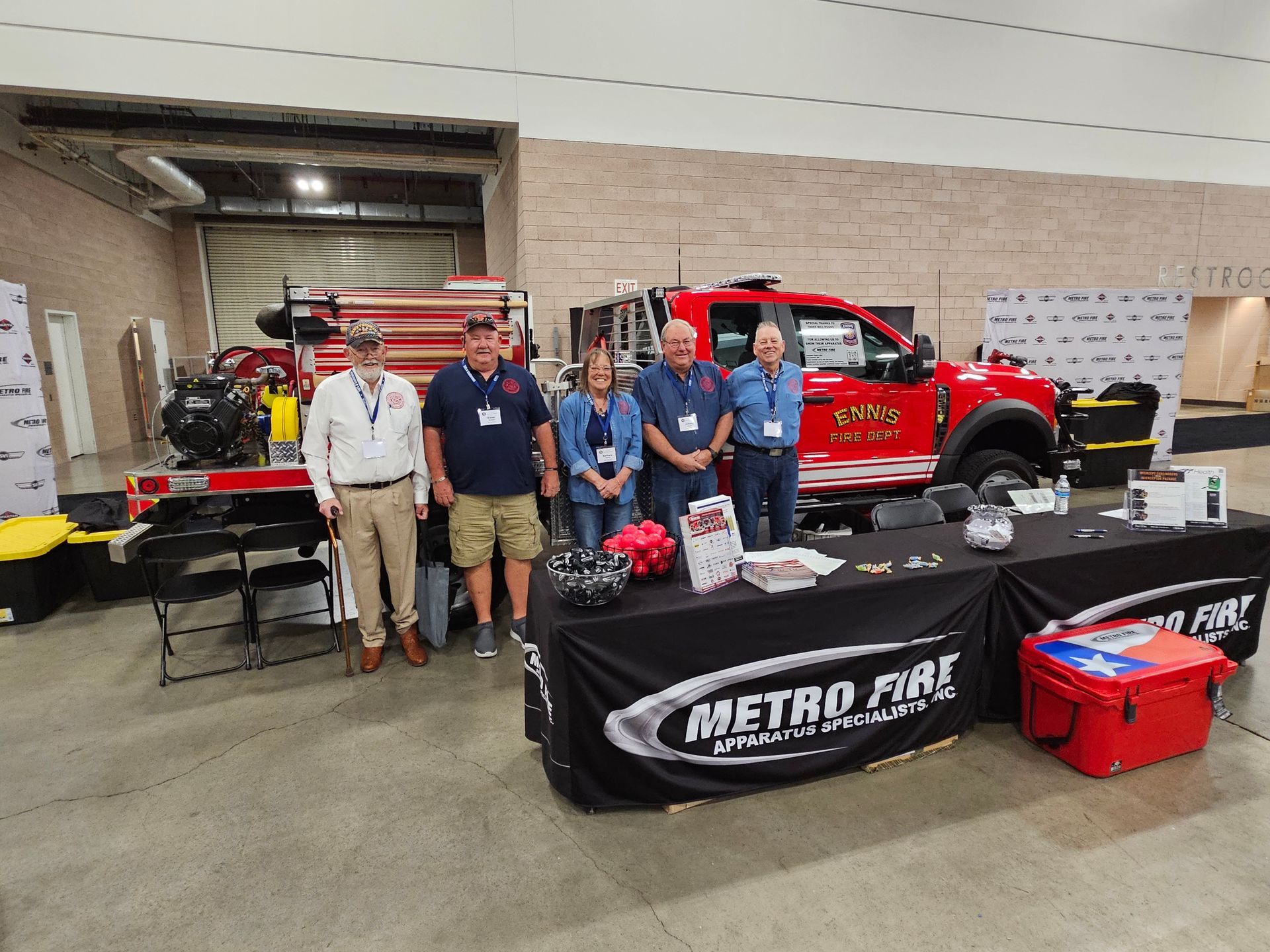 A group of people standing in front of a red fire truck.