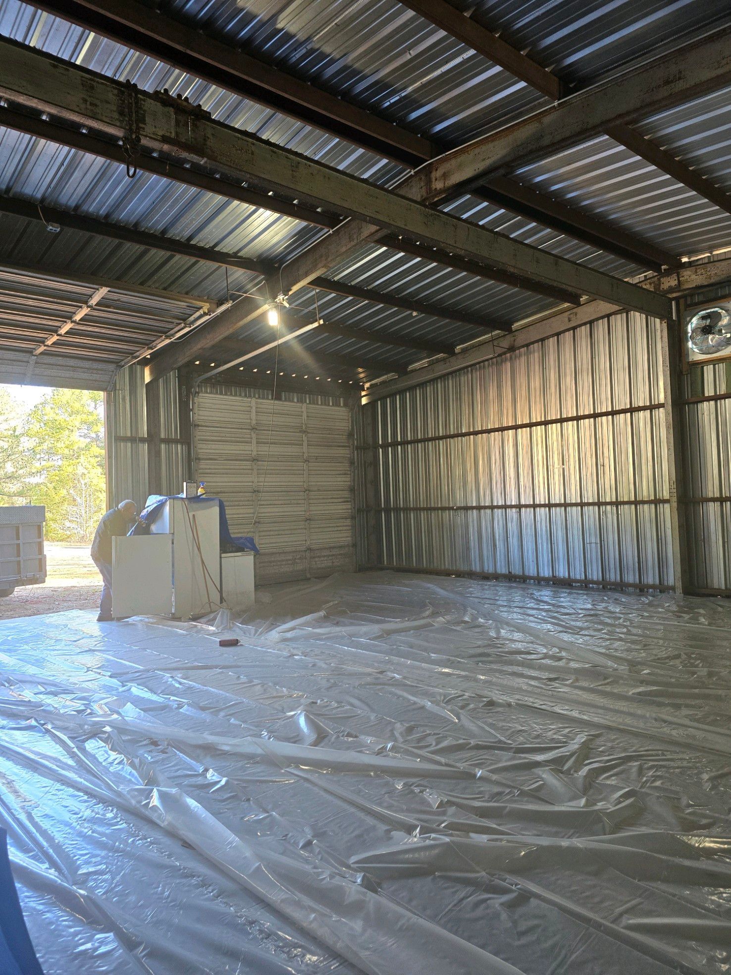 A large empty warehouse with a tarp on the floor.