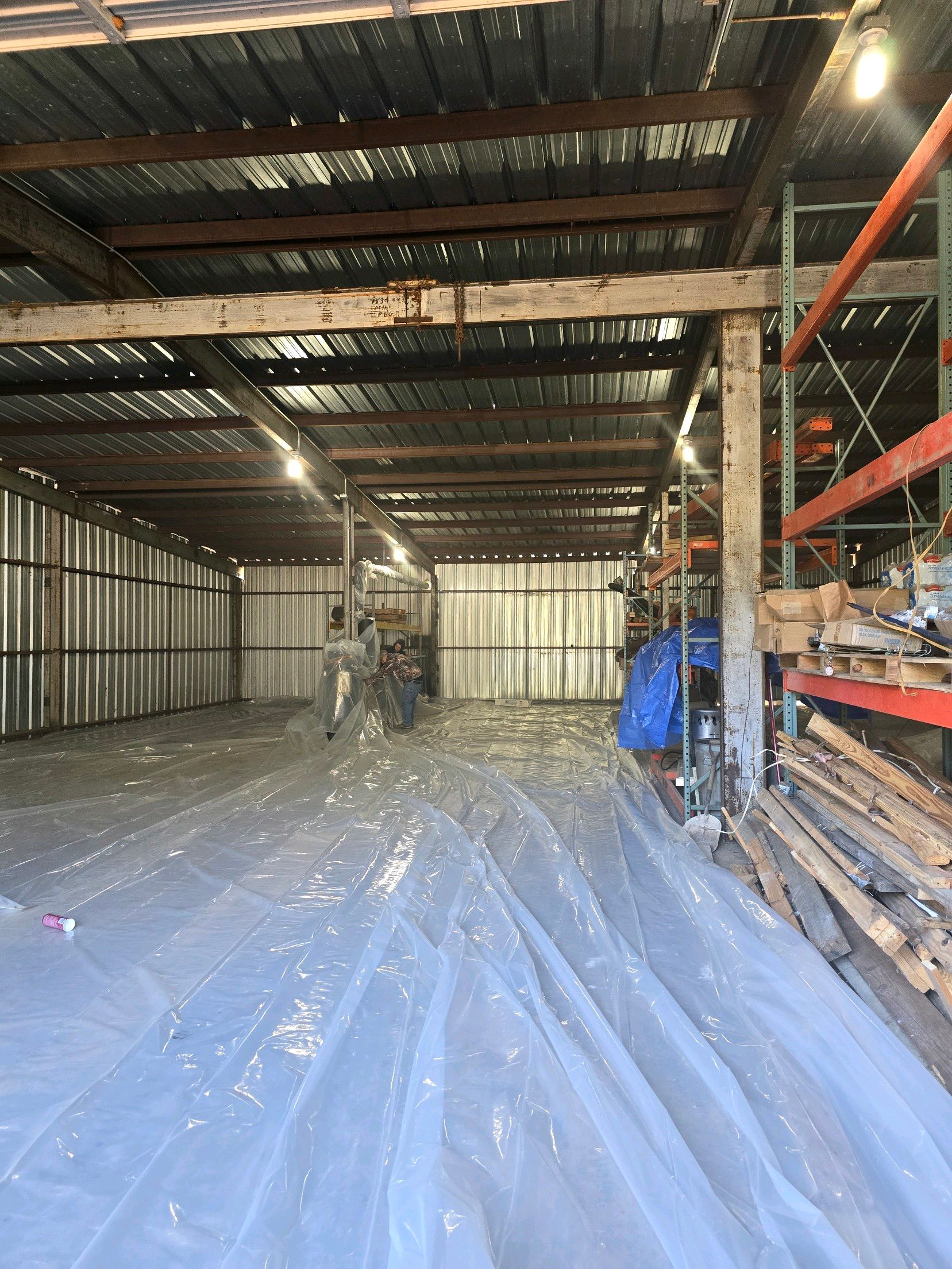 A large warehouse with a lot of plastic covering the floor.