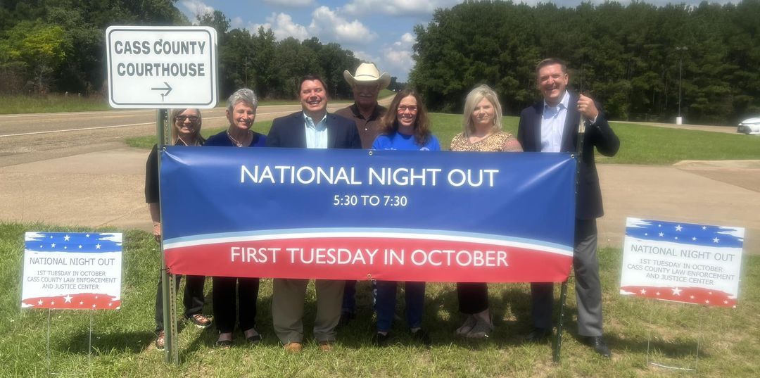 A group of people are holding a National Night Out banner.