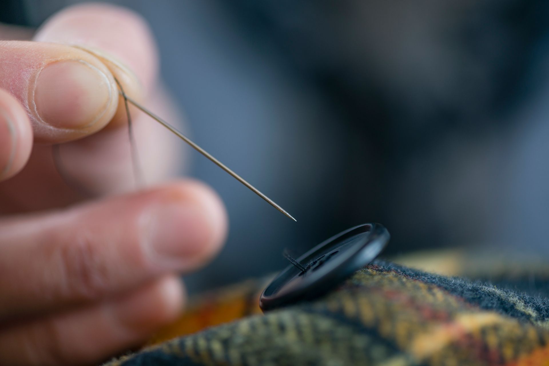 Close up seamstress fingers sewing button onto tartan | Newcastle, AU - Mattara Dry Cleaning
