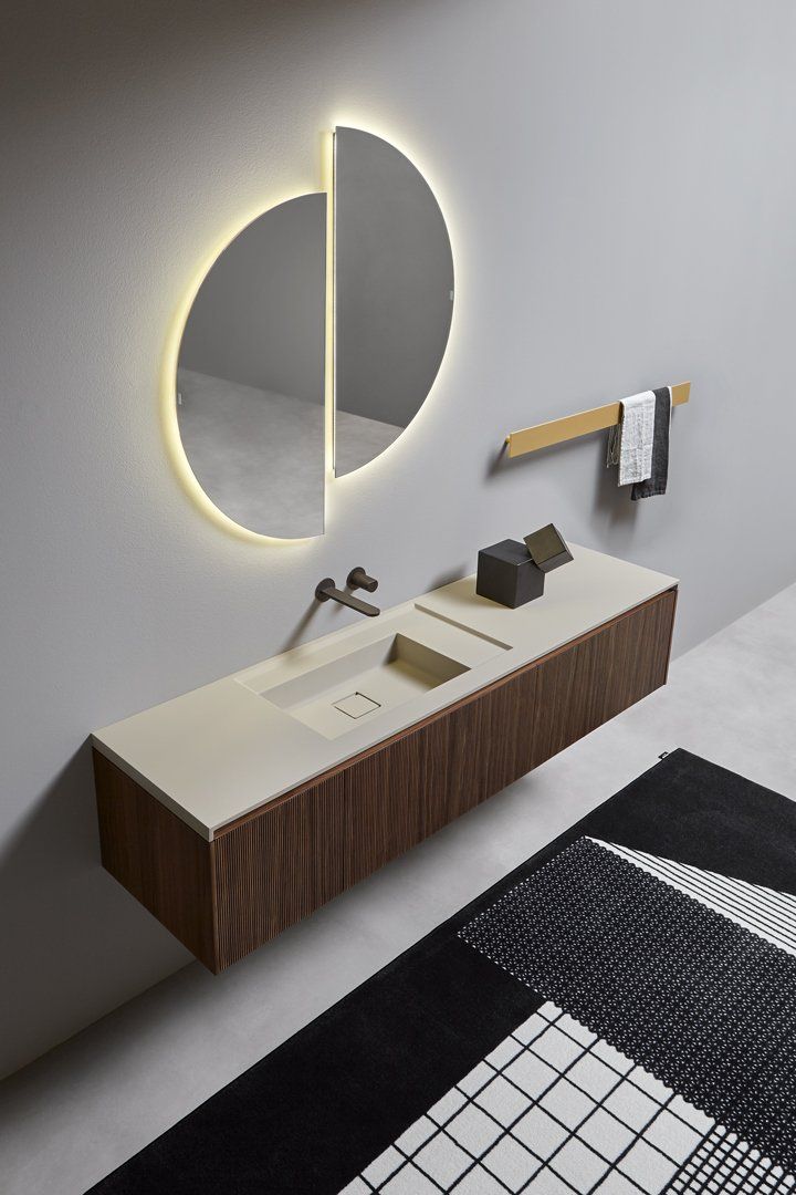 Een badkamer met een wastafel en een spiegel aan de muur.
