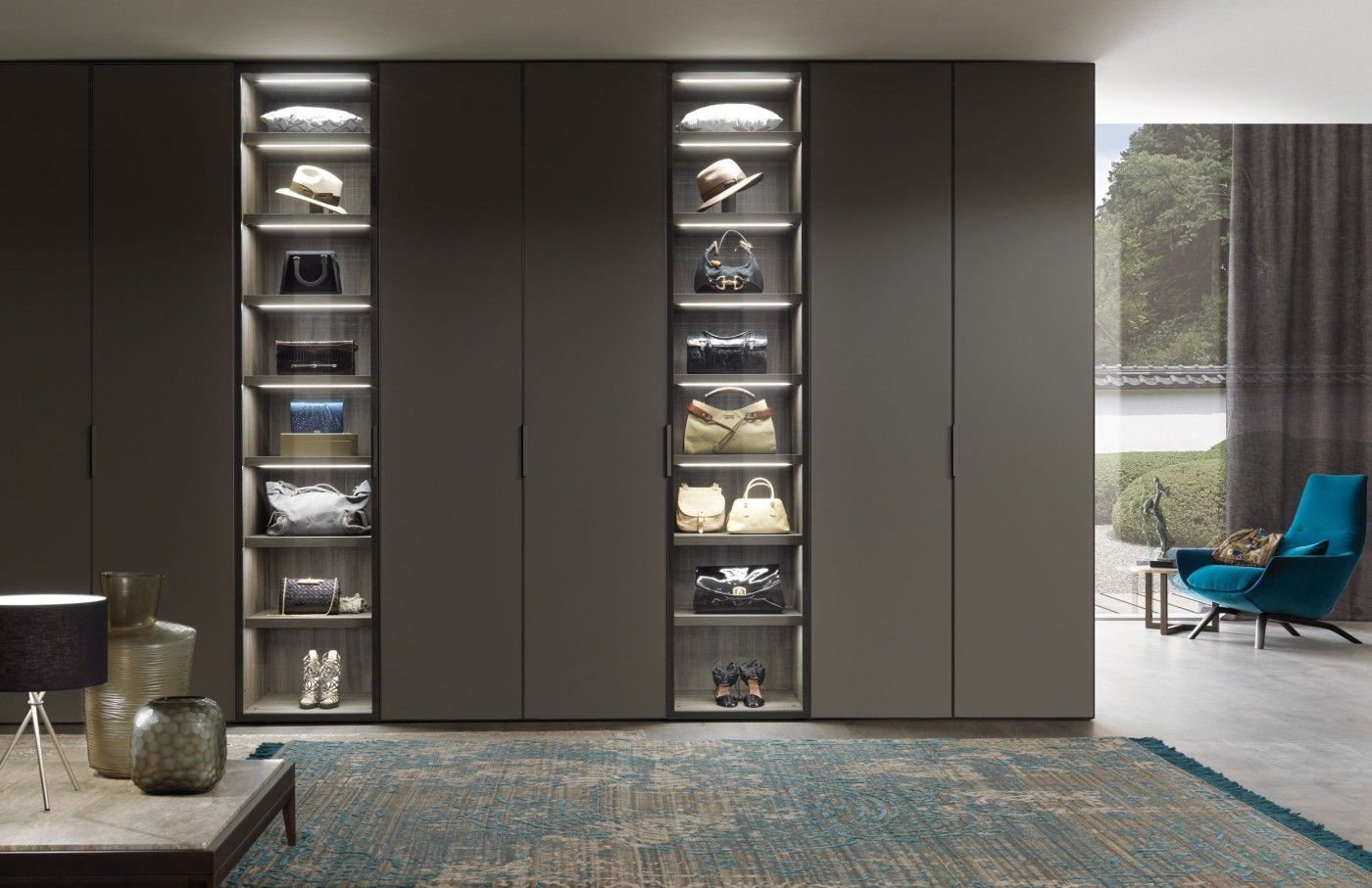 Een woonkamer met een grote kledingkast vol met handtassen en schoenen.