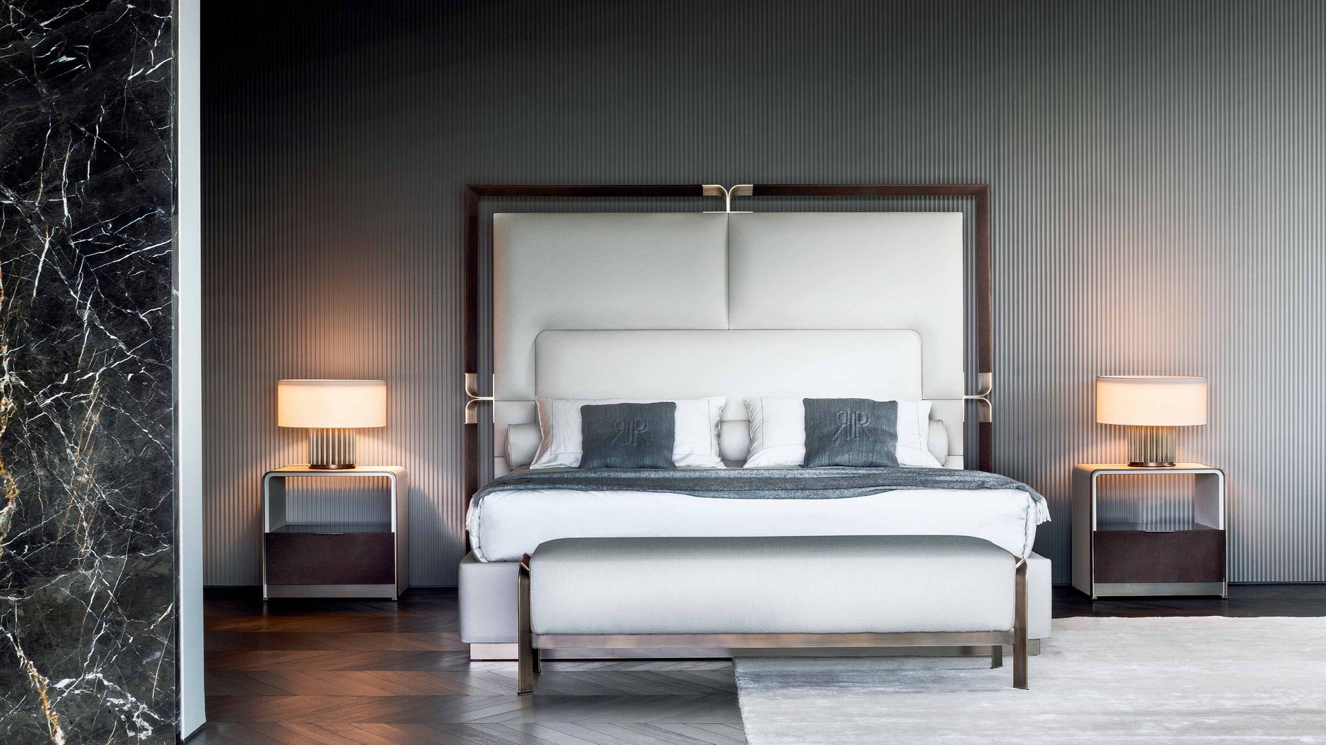 Een slaapkamer met een bed, nachtkastjes en lampen.