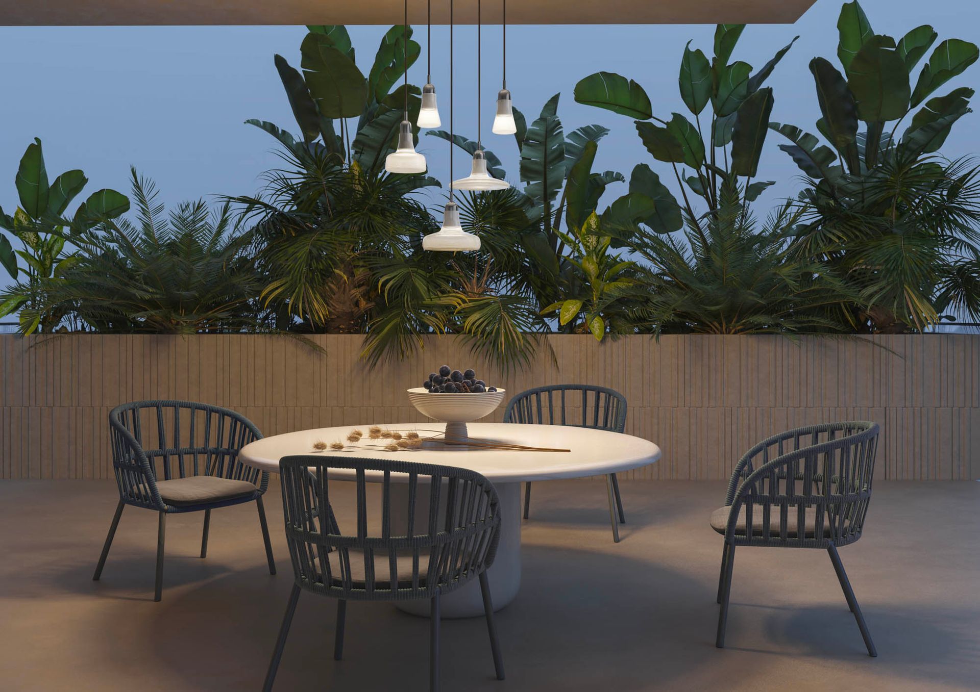 Een tafel en stoelen op een terras met een schaal met druiven erop.