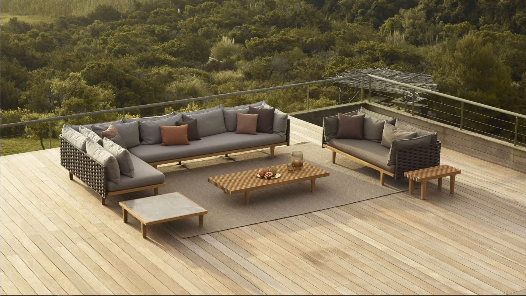 Een houten terras met een bank en twee salontafels