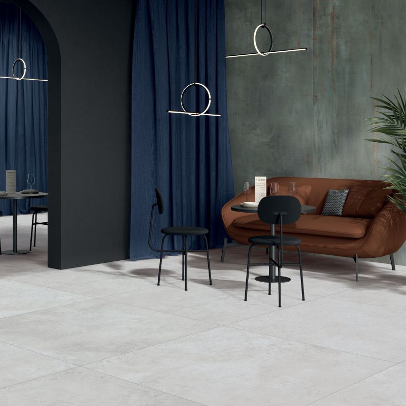 Een woonkamer met een bruine bank en zwarte stoelen