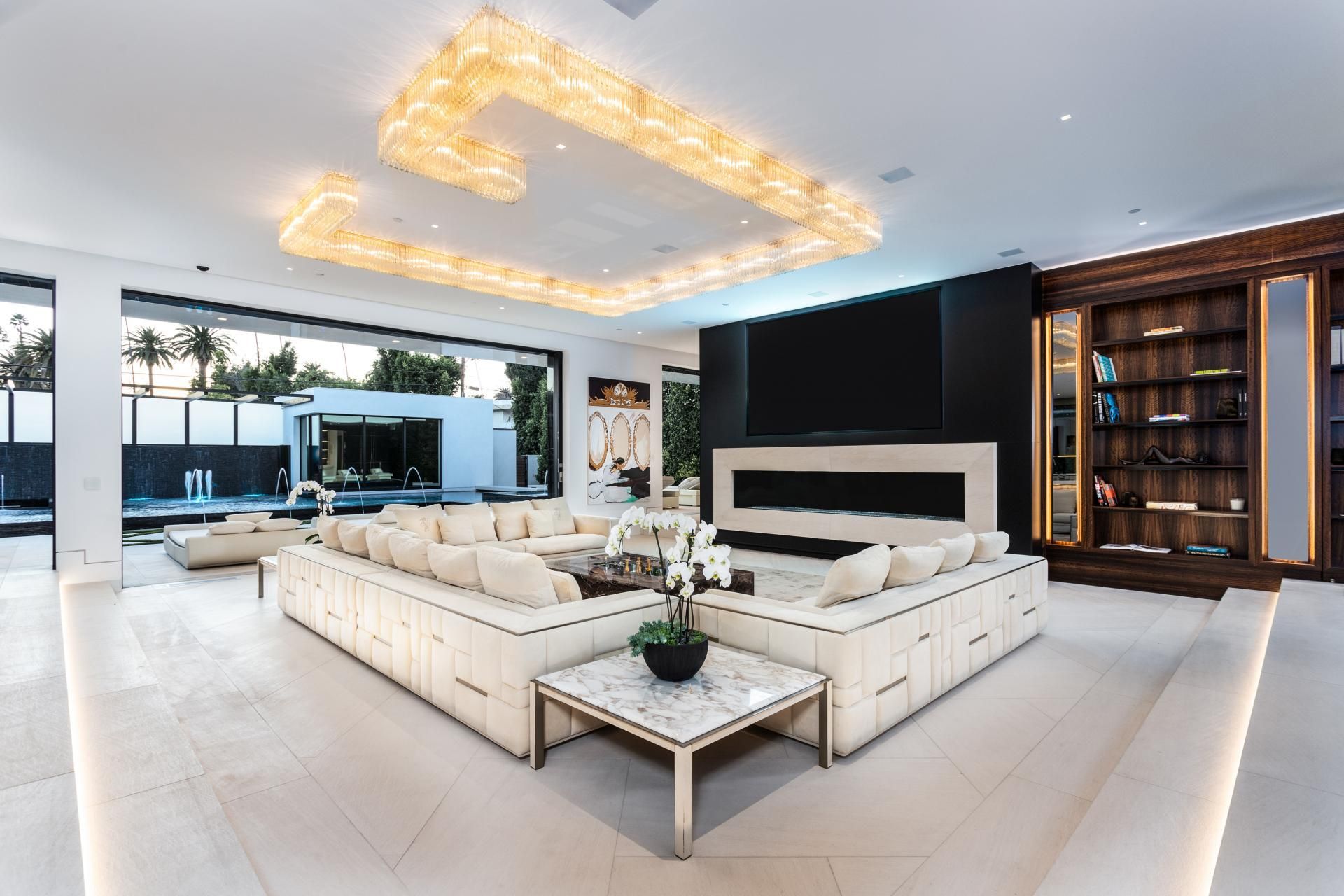 Een woonkamer met een grote witte bank en een open haard.