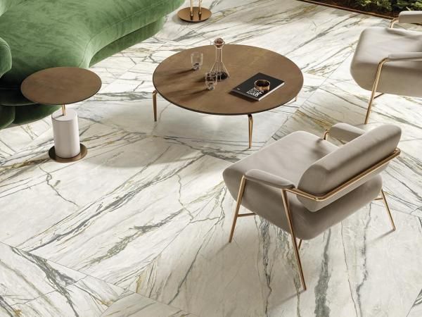 Een woonkamer met een groene bank, stoelen, tafels en een salontafel