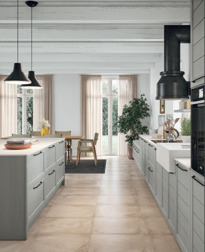 Een keuken met grijze kasten en een witte gootsteen