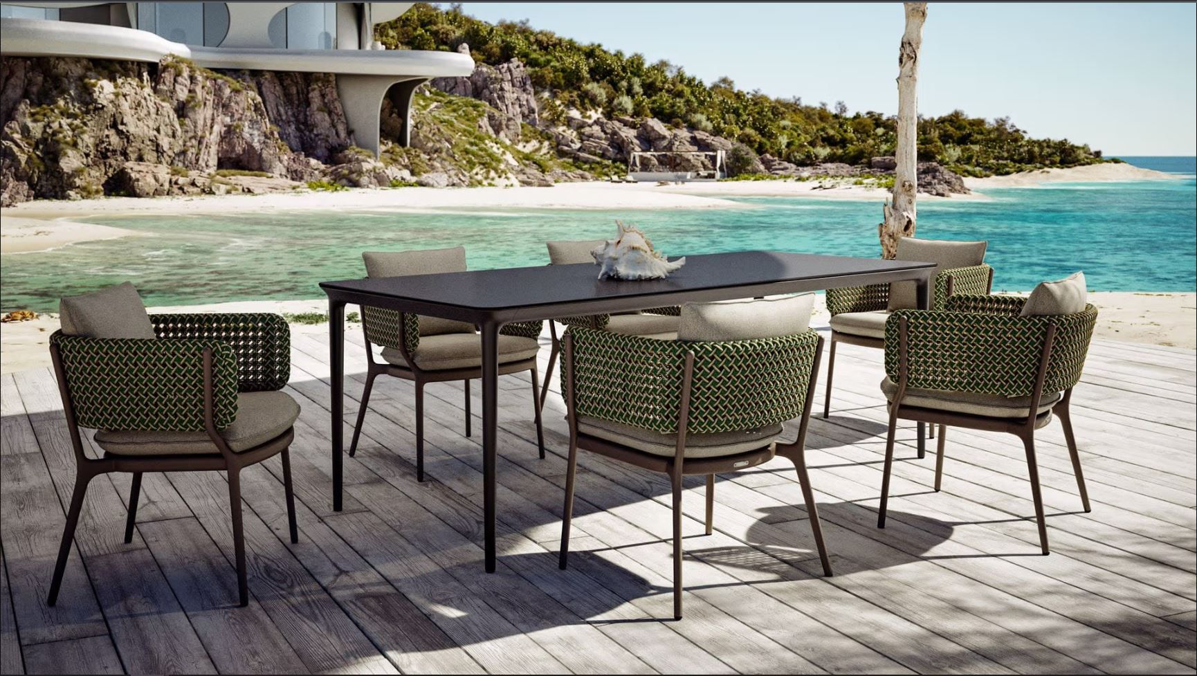 Een tafel en stoelen staan ​​op een houten terras vlak bij de oceaan.