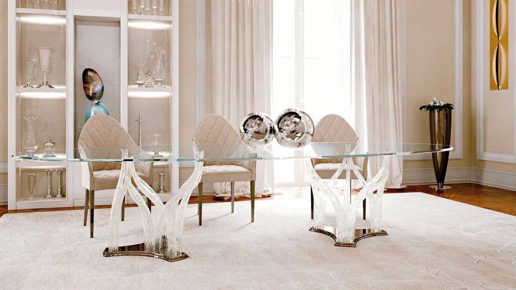 Een eetkamer met een glazen tafel en stoelen
