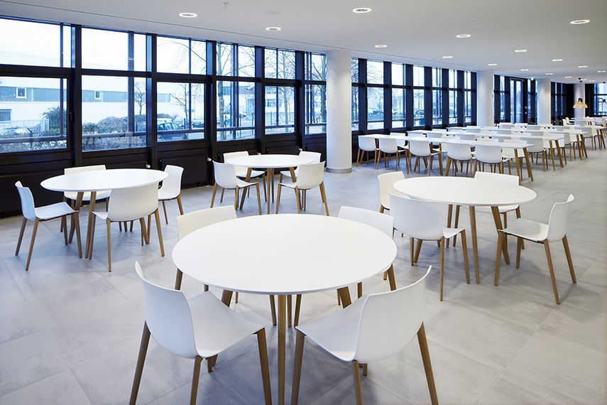 Een grote kamer met tafels en stoelen erin