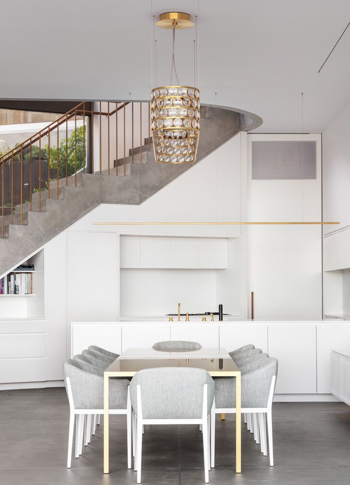 Een eetkamer met een tafel en stoelen en een trap op de achtergrond
