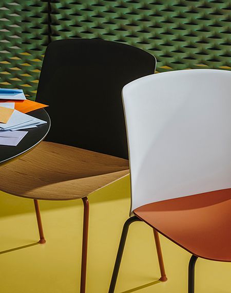 Er staan ​​twee stoelen naast een tafel met papieren erop.
