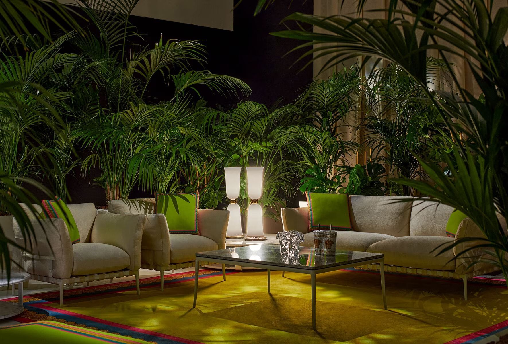 Een woonkamer vol met meubels en planten 's nachts.