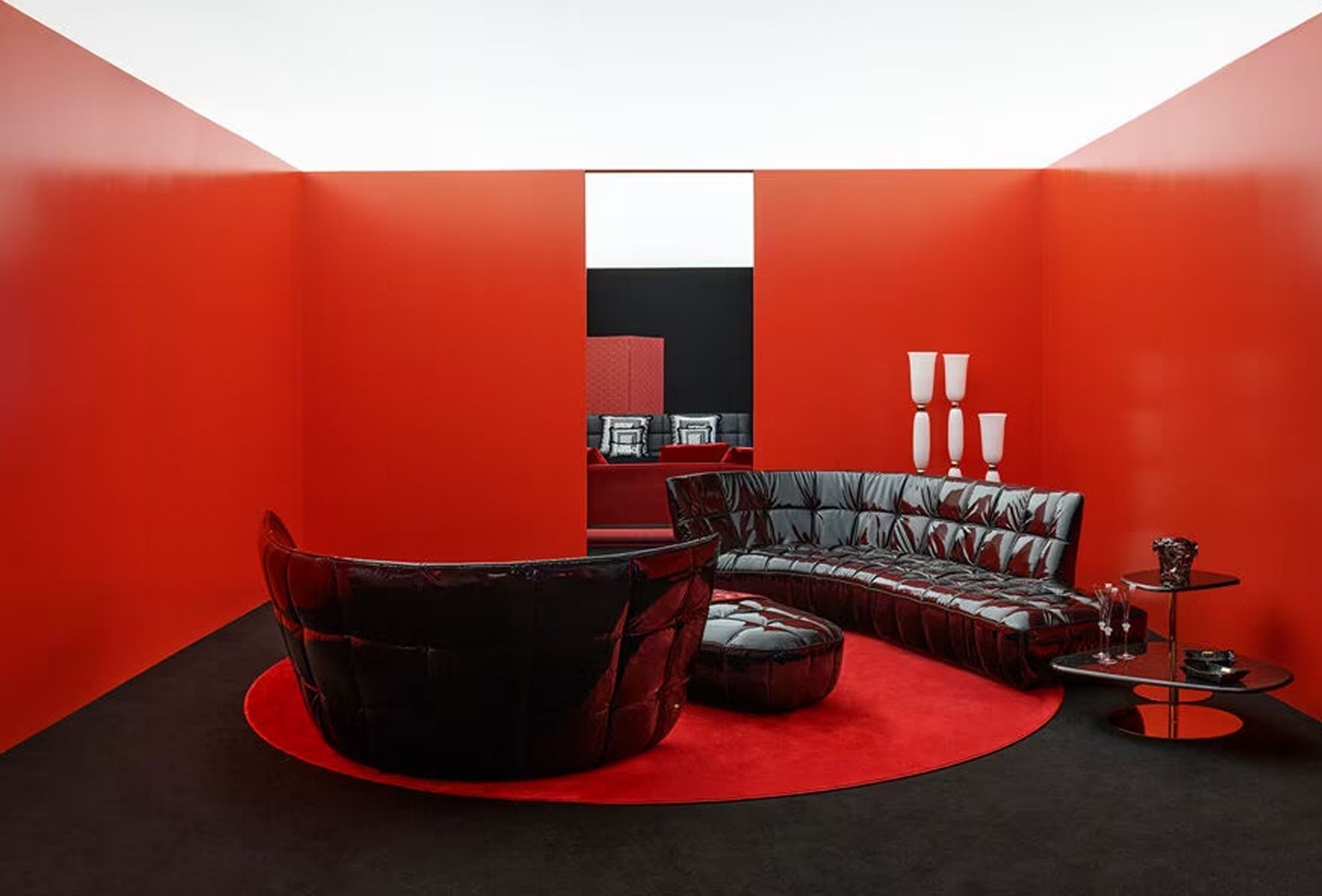 Een woonkamer met rode muren en een zwarte bank