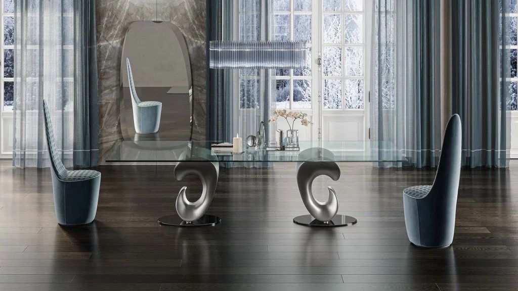 Een eetkamer met een glazen tafel, stoelen en een spiegel.