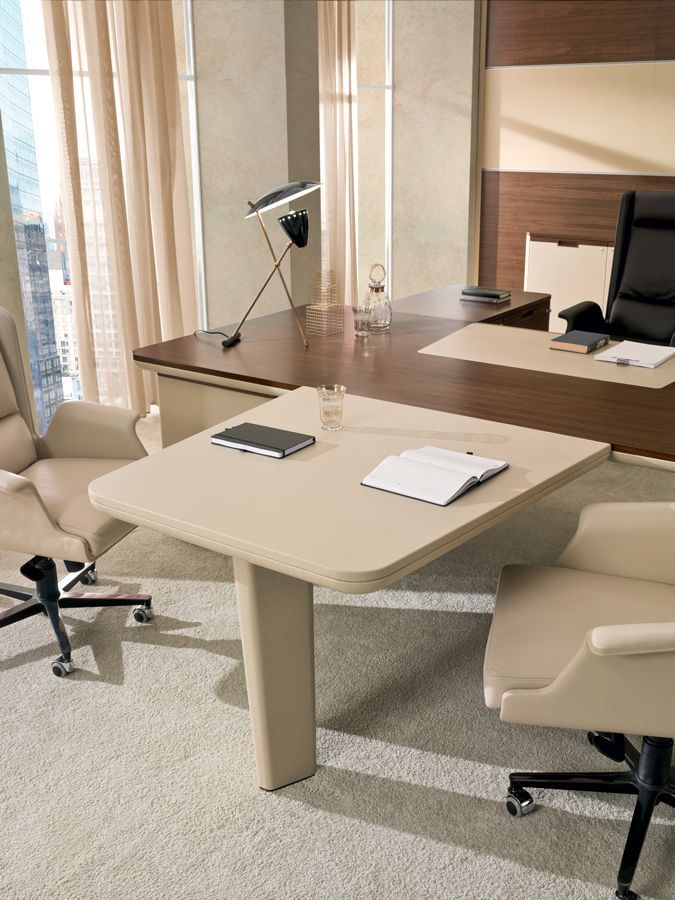 Een kantoor met twee stoelen en een tafel met een boek erop