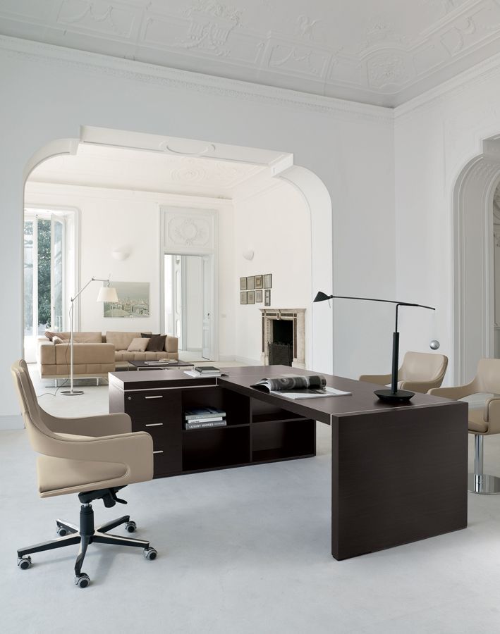 Een kamer met een bureau en stoelen erin