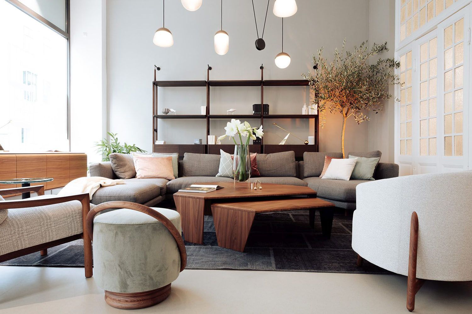 Een woonkamer met een bank, stoelen en een salontafel