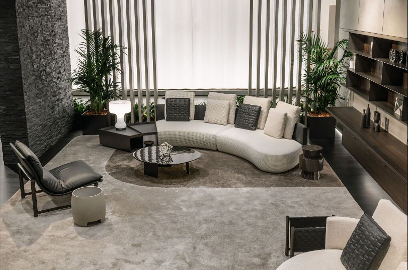 Een woonkamer met een gebogen bank en stoelen
