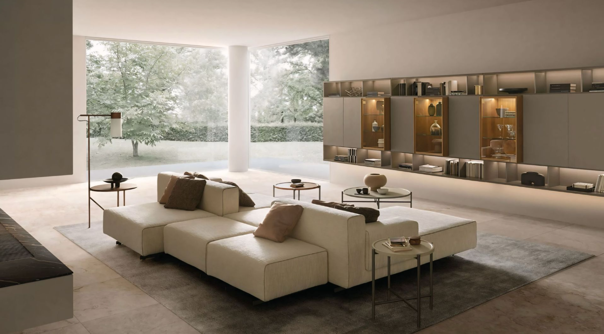 Een woonkamer met een grote witte bank en een groot raam.