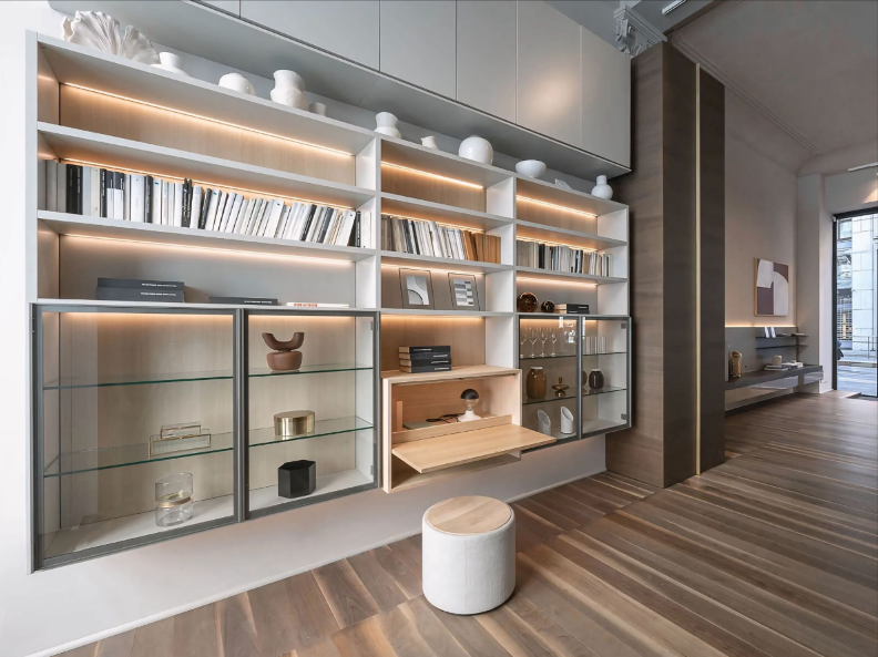 Een kamer met veel planken en een bureau.