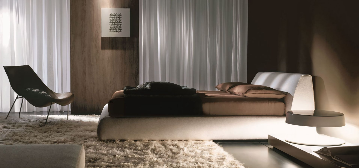 Een slaapkamer met een bed, een stoel en een kleed