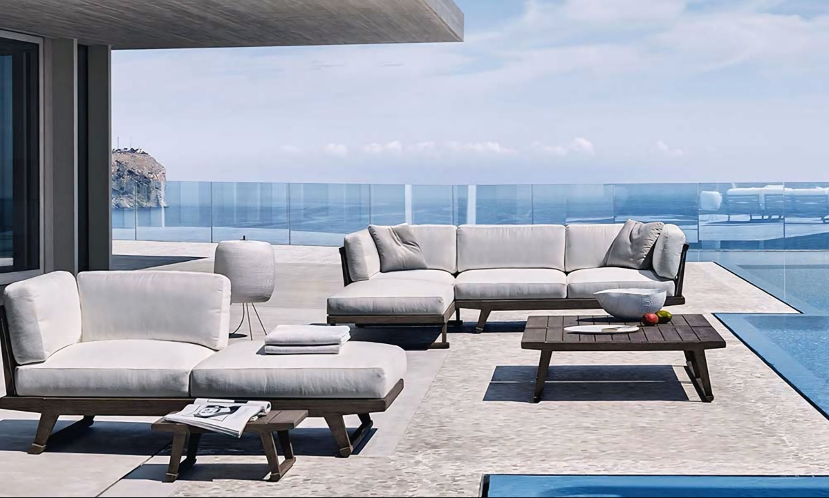 Een terras met een bank, een salontafel en uitzicht op de oceaan.