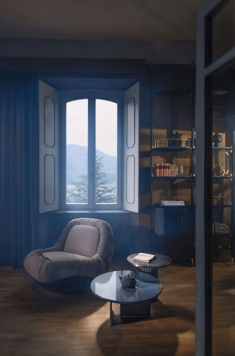 Een woonkamer met een stoel en twee tafels voor een raam