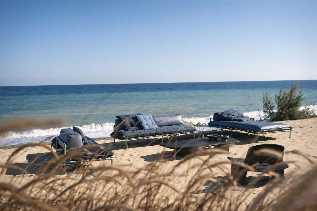 Er zijn veel stoelen en tafels op het strand.