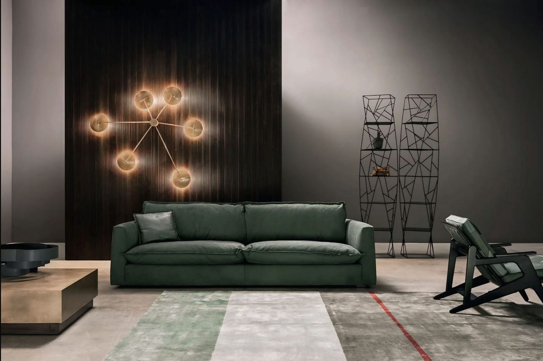 Een woonkamer met een groene bank en een stoel