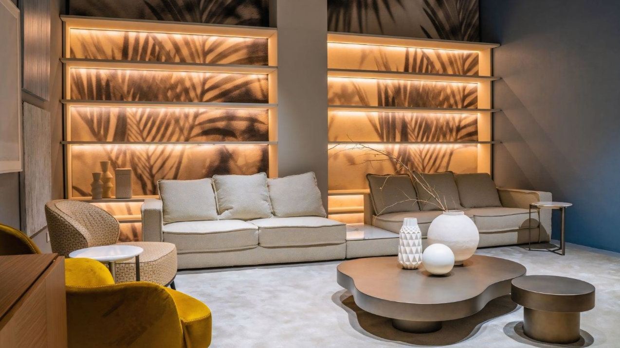 Een woonkamer met een bank, stoelen, tafels en planken.